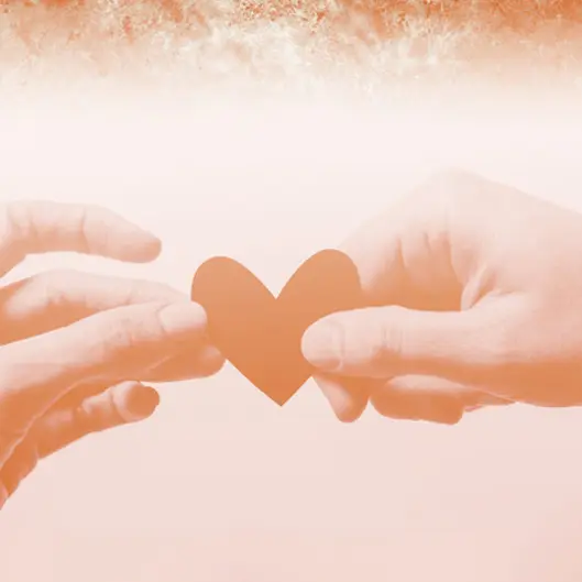 Zwei Hände halten ein Herz aus Papier